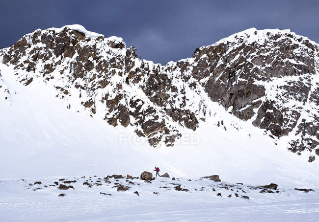 Mulher snowshoe caminhadas em montanhas nevadas durante o nascer do sol no inverno — Fotografia de Stock