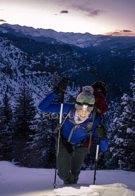Woman backpacking during sunrise in mountains with headlamp — Stock Photo