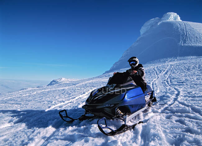 Uomo cavalcando il suo scooter neve su Snaefellsnesjokull ghiacciaio — Foto stock