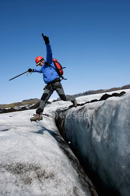 Man jumping over crevasse on the glacier Solheimajokull in Iceland — Stock Photo