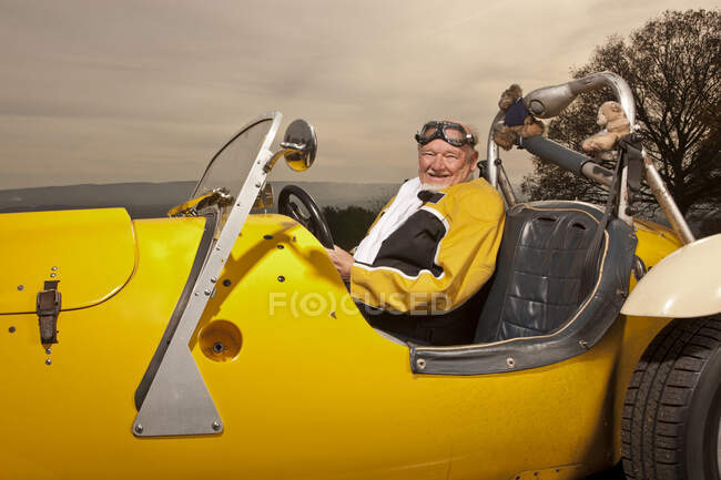 Vieil homme en voiture rétro jaune — Photo de stock