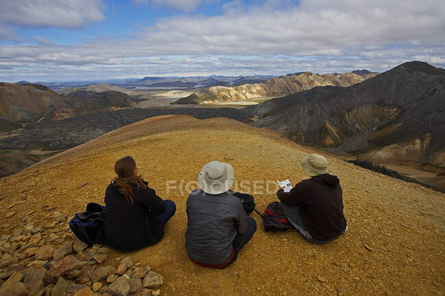 Un grupo de excursionistas disfrutando de la vista a Landmannalaugar desde la cima de la montaña Brennisteinsalda - foto de stock