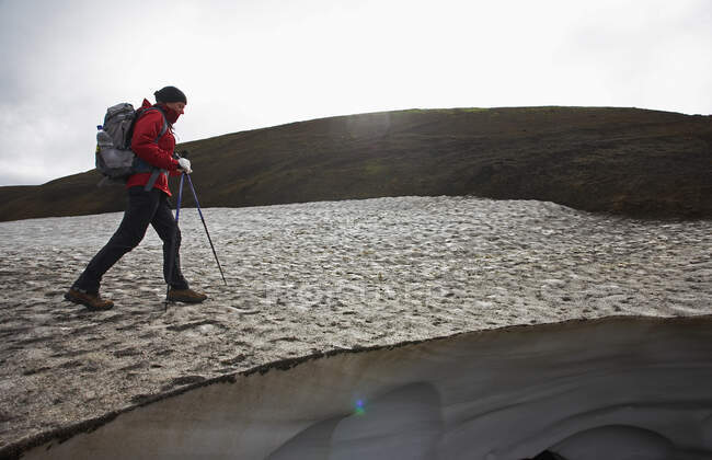 Escursionista femminile sul Laugarvegur Trail attraversando un campo di neve — Foto stock