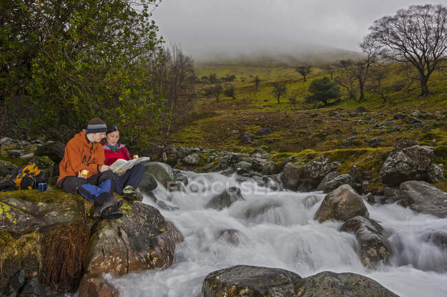 Casal ler mapa no caminho até Scafell Pike, no Lake District — Fotografia de Stock