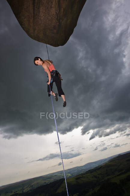 Escalade féminine descendant falaise dans le Peak District en Angleterre — Photo de stock