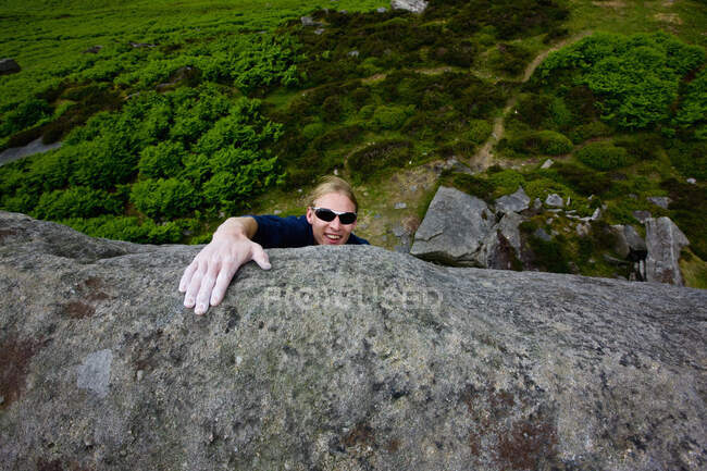 Climber topping out from a climb at Stanage edge in the Peak District — Stock Photo
