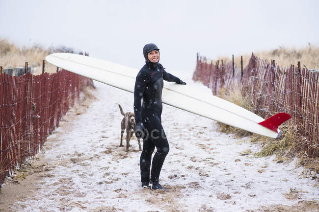 Молода жінка збирається серфінг взимку сніг — стокове фото