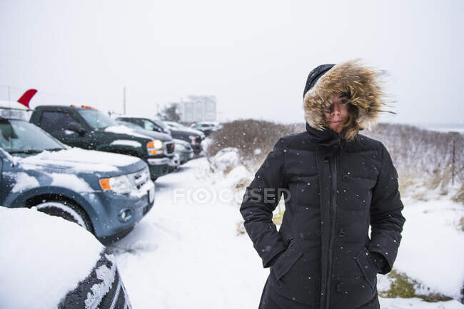Woman preparing to go surfing during winter snow — Stock Photo