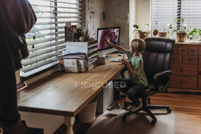 Wide view of young student getting virtual high five from teache — Stock Photo