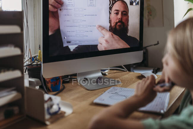 Behind view of school aged boy learning from teacher conducting — Stock Photo