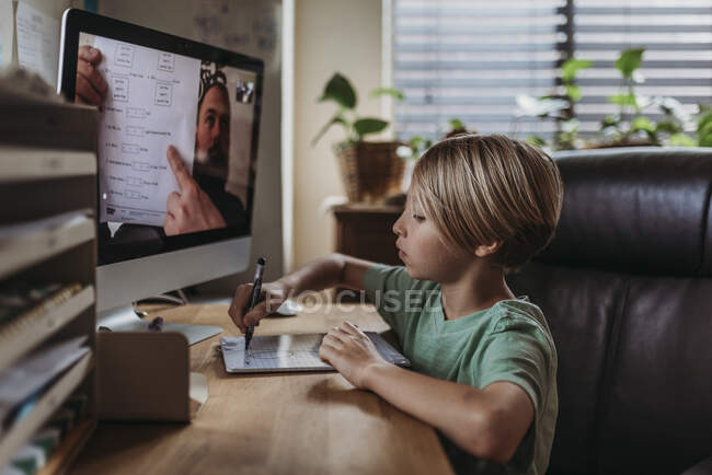 Side view of school aged boy learning from teacher conducting cl — Stock Photo