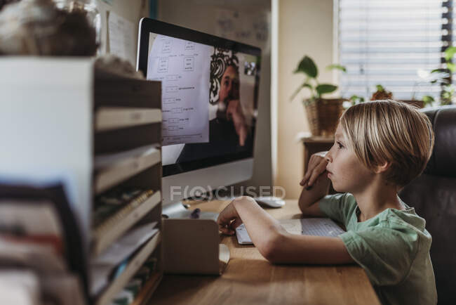 Elementary age boy taking online class from teacher during isola — Stock Photo