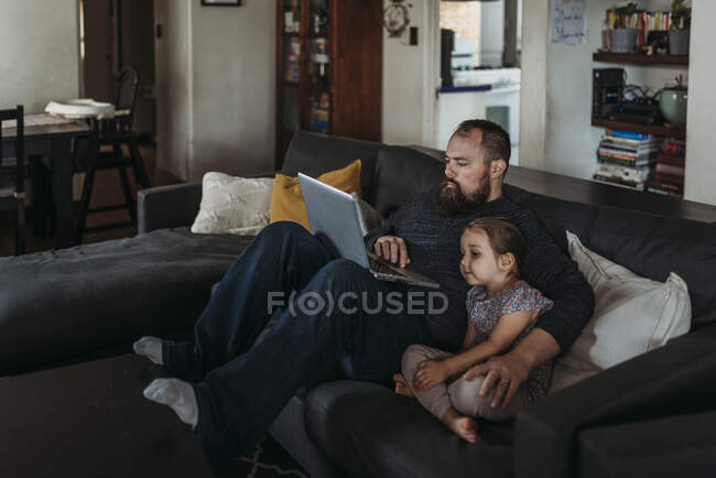 Padre che lavora da casa con la figlia durante l'isolamento — Foto stock