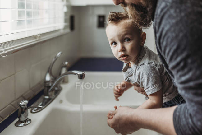 Menino lava as mãos com sabão — Fotografia de Stock