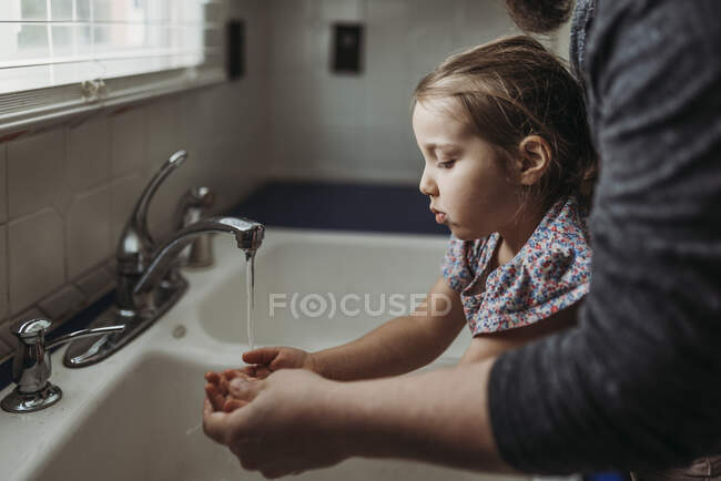 Menina lavar as mãos na pia do banheiro com sabão. — Fotografia de Stock
