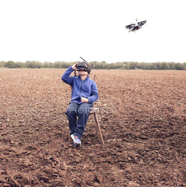 Niño lanzando su dron en primavera - foto de stock