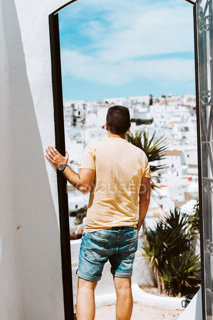 Junger Reisender blickt durch Tür über weißes spanisches Dorf — Stockfoto