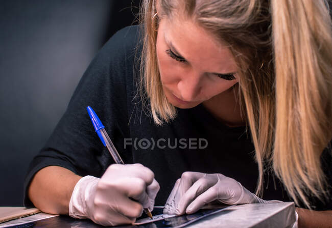 Femme tatoueuse dessine un tatouage — Photo de stock