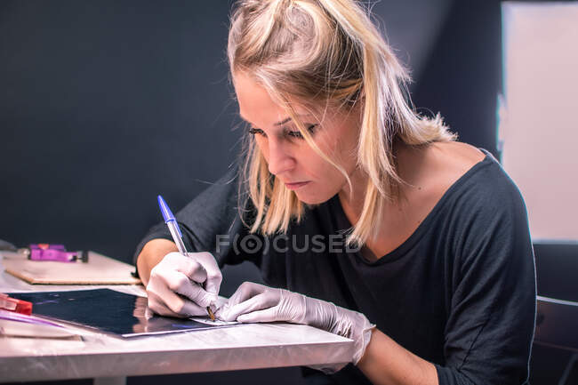 Tatuaggio artista femminile disegna un tatuaggio — Foto stock