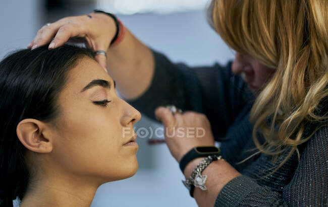 Close-up of a make-up artist touching up a model's face — Stock Photo