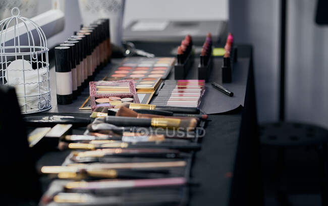 Maquiagem de paletas e pincéis em uma mesa de vestir — Fotografia de Stock
