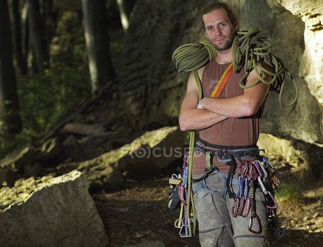 Rock climber posing with climbing rope on his shoulders — Stock Photo