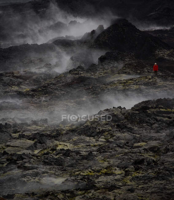 Mujer caminando por el campo de lava en el volcán Krafla - foto de stock