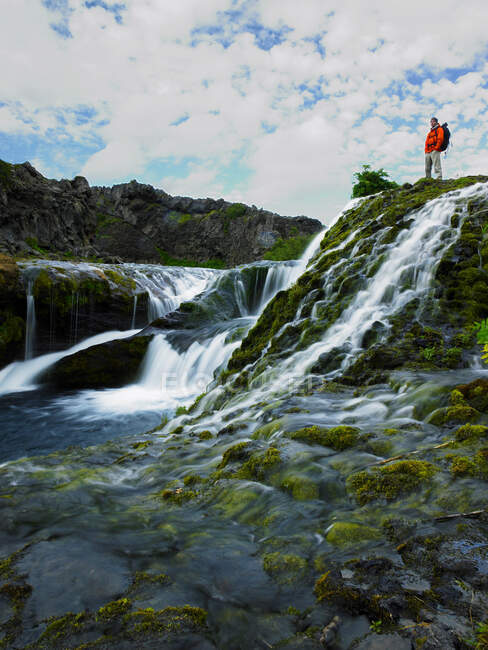 Uomo in piedi sopra bella cascata a Thjorsardalur — Foto stock