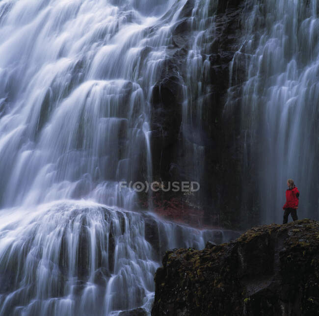 Frau bewundert Dynjandi-Wasserfall in den abgelegenen Fjorden Islands — Stockfoto