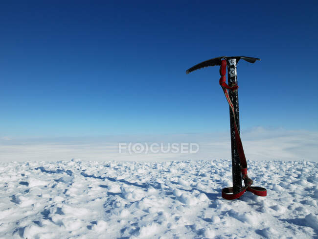 Pic à glace coincé dans la neige au sommet d'une montagne — Photo de stock