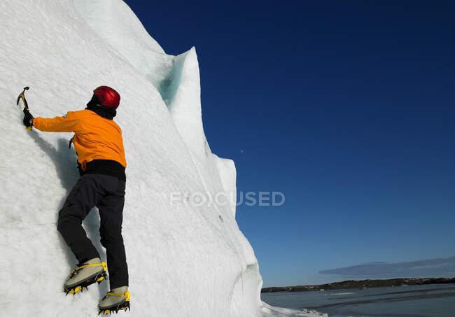Uomo che si arrampica sul fianco di un ghiacciaio nel sud dell'Islanda — Foto stock