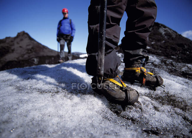 Close up of man wearing crampons on glacier — Stock Photo