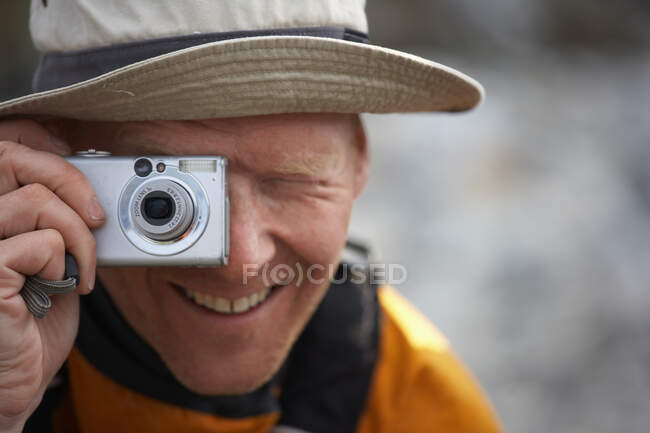 Hombre tomando fotos con el punto digital y disparar la cámara en Groenlandia - foto de stock