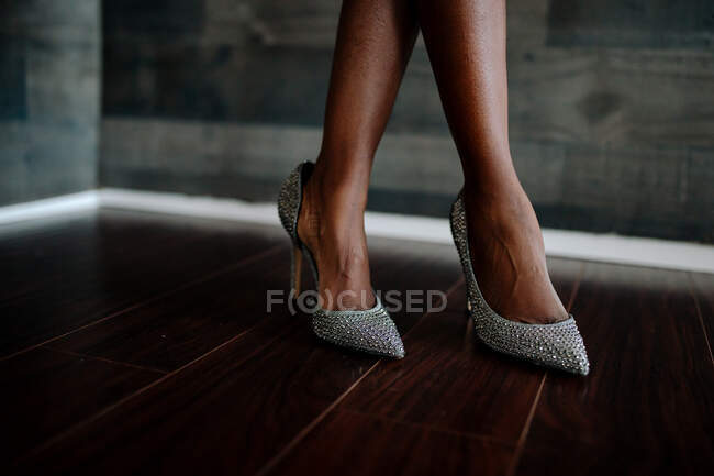 Sexy ethnic feet wearing classy silver rhinestone high heels — Stock Photo