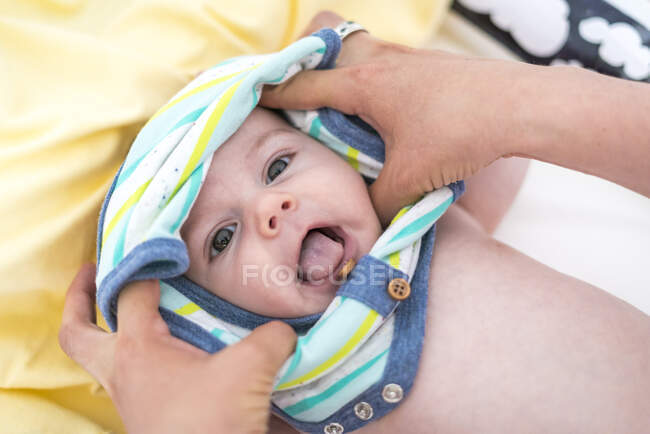Vue aérienne de la mère habillant bébé garçon à la maison — Photo de stock