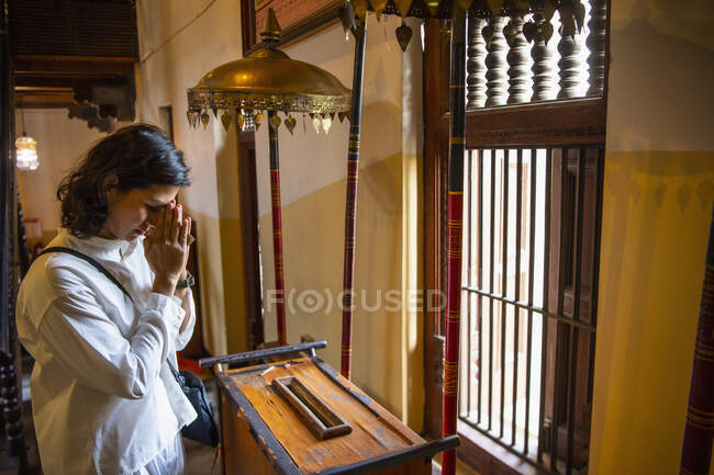 Adorador budista donando en el templo de la reliquia del diente santo - foto de stock