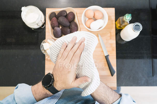 Обрізаний знімок людини в джинсовій сорочці, що готується на кухні — стокове фото