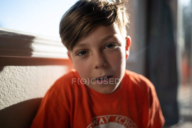 Portrait d'un garçon à l'intérieur regardant la caméra avec une belle lumière — Photo de stock