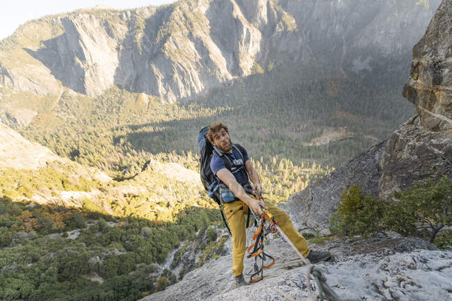 Uomo giocoleria corda su El Capitan facendo faccia divertente con lo zaino — Foto stock