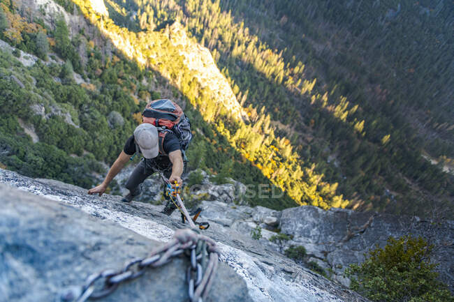 Homem com chapéu olhando para baixo jugging corda com mochila em El Capitan — Fotografia de Stock