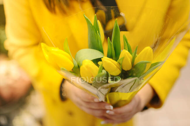 Unrecognizable woman with a bouquet of yellow tulips. She just receive — Stock Photo