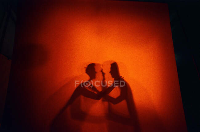 Amantes de las sombras en fondo naranja - foto de stock