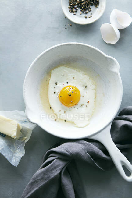 Сирі яйця на сковороді на сірому фоні — стокове фото