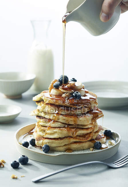Stack of tasty pancakes with honey and berries on white plate — Stock Photo