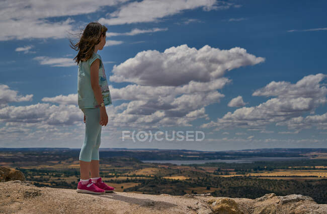 Girl with her back to an incredible landscape of plateau lands and blu — Stock Photo