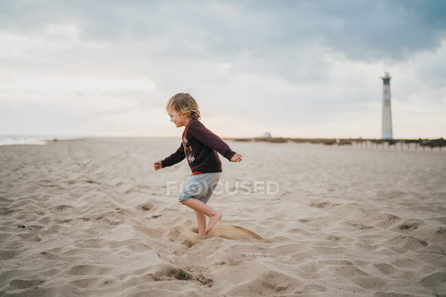 Pequeno menino no mar, o oceano está na costa da praia. — Fotografia de Stock