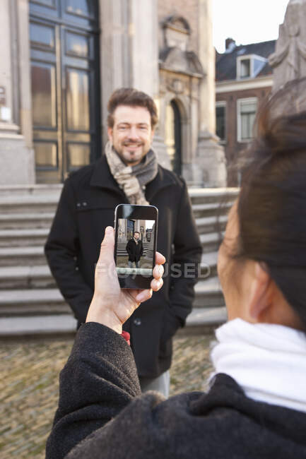 Mulher tirando foto de homem com smartphone em Middelburg — Fotografia de Stock
