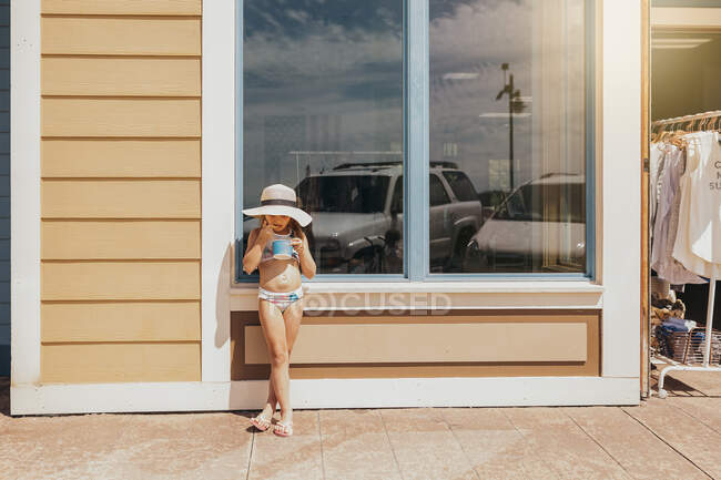 Menina bonita em um maiô e chapéu na praia — Fotografia de Stock