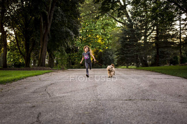 Girl Running with Dog on Leash — Stock Photo