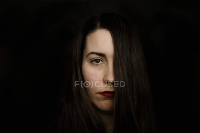 Retrato de cerca de una mujer seria con lápiz labial rojo - foto de stock